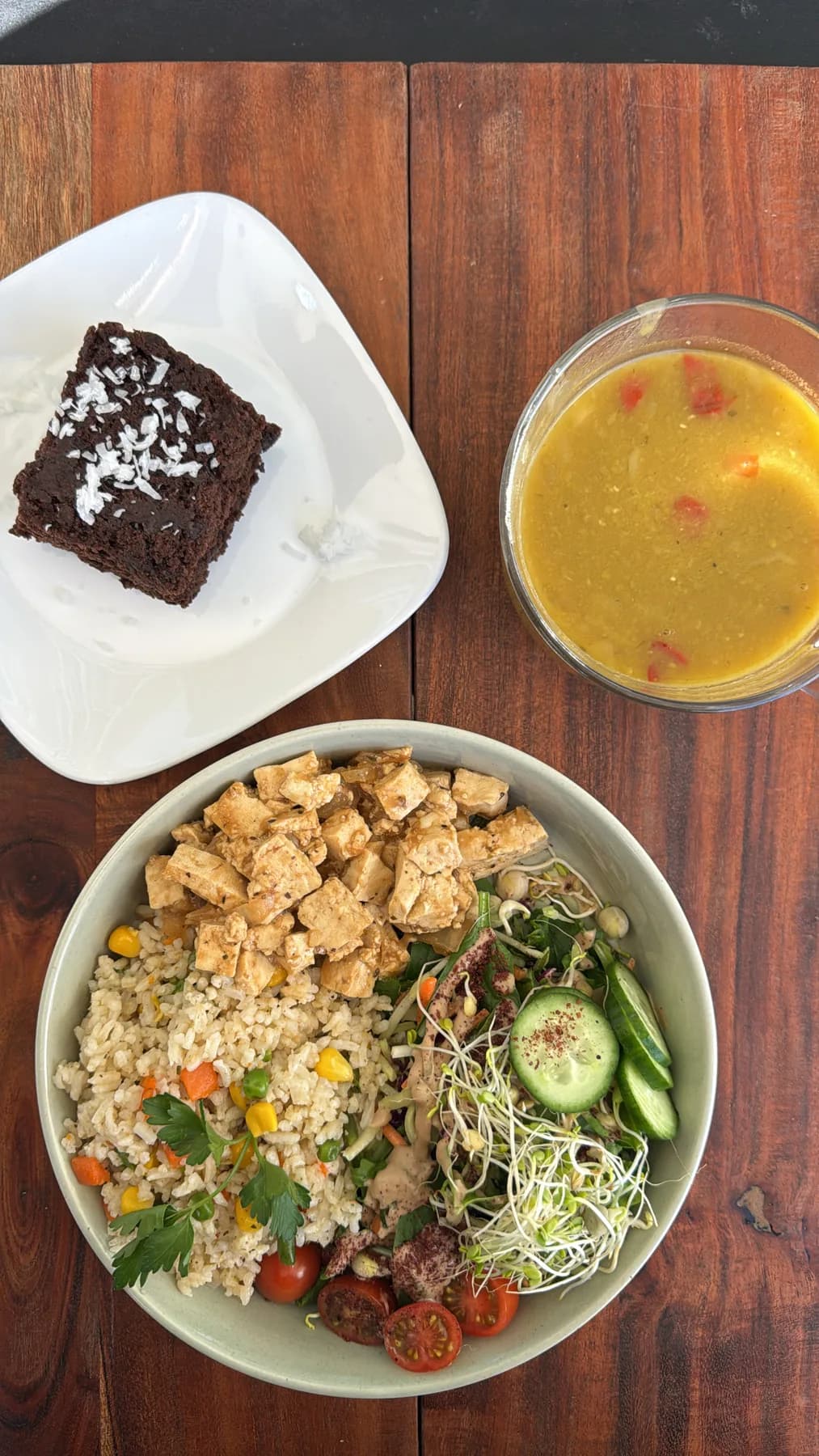 A fresh Raw South bowl and juice on a wood table.
